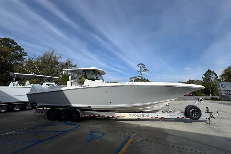 Slide: The Image of 2023 Fountain 38 Tournament Edition boat on trailer, parked outdoors under clear sky. - 10