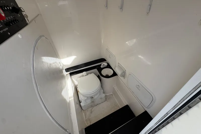 Slide: The Image of 2023 Fountain 38 Tournament Edition boat interior with compact marine toilet and storage compartments. - 19