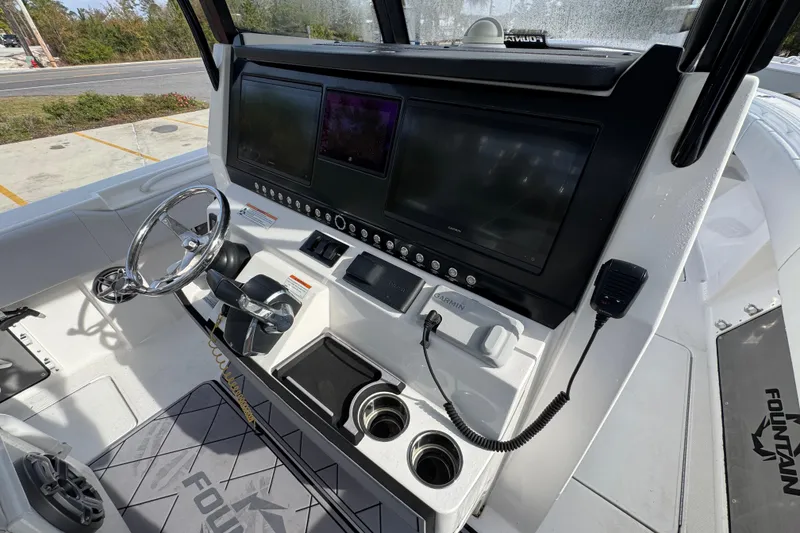Slide: The Image of 2023 Fountain 38 Tournament Edition boat dashboard with steering wheel and electronic displays. - 21