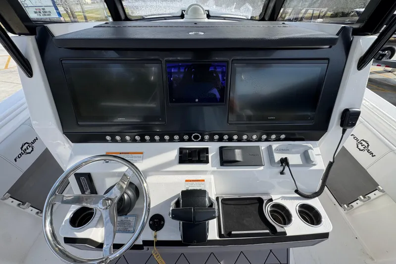 Slide: The Image of 2023 Fountain 38 Tournament Edition boat dashboard with dual Garmin displays and steering wheel. - 22
