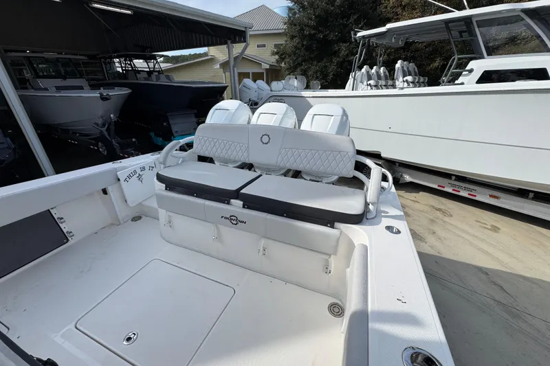 Slide: The Image of 2023 Fountain 38 Tournament Edition boat with cushioned seating in a marina setting. - 31