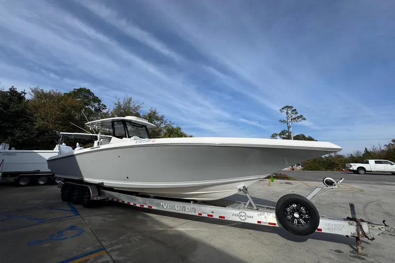 Slide: The Image of 2023 Fountain 38 Tournament Edition boat on trailer, parked outdoors under blue sky. - 8
