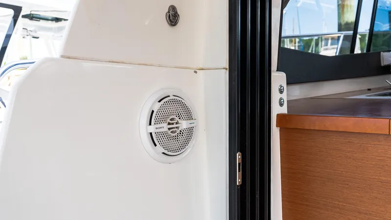Slide: The Image of 2018 Jeanneau NC11 boat interior with speaker and wooden cabinetry. - 10