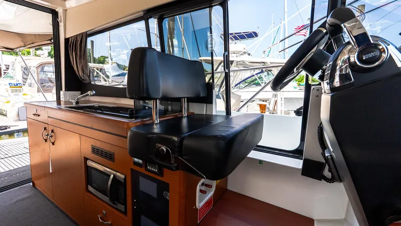 Slide: The Image of Interior of 2018 Jeanneau NC11 boat with helm and kitchenette area. - 29