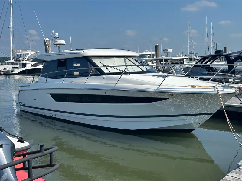 Slide: The Image of 2018 Jeanneau NC11 yacht docked at marina under clear blue sky. - 4