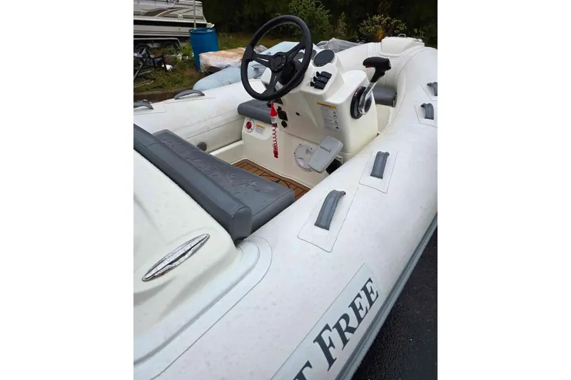 Slide: The Image of 2021 Brig Eagle 340 inflatable boat interior with steering wheel and seating. - 2