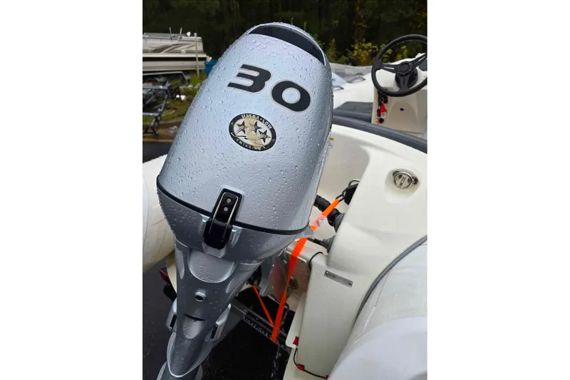 Slide: The Image of 2021 Brig Eagle 340 boat with a 30 HP outboard motor, wet with raindrops. - 3
