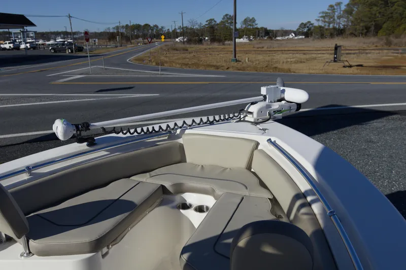 Slide: The Image of 2022 Key West 219 FS boat with seating and trolling motor, parked near a road. - 13