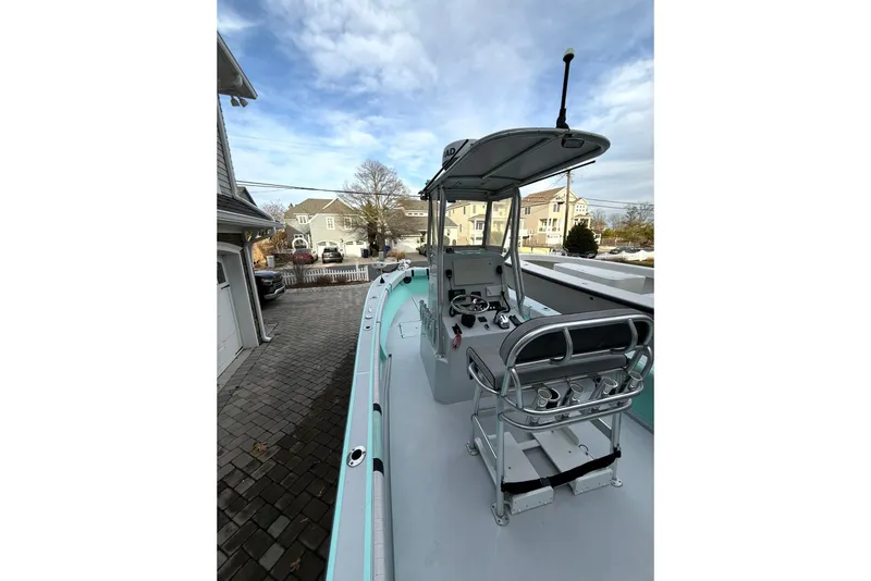 Slide: The Image of 2019 Latitude Tournament Boats 25, docked, showcasing helm and seating under clear sky. - 13