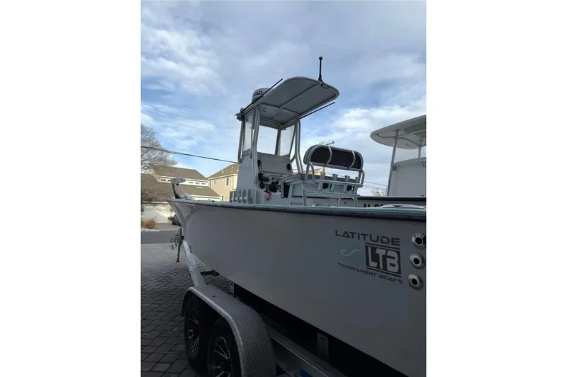 Slide: The Image of 2019 Latitude Tournament Boats 25 on trailer, side view under cloudy sky. - 4