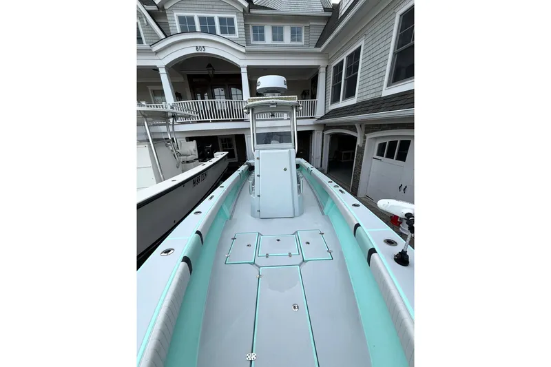 Slide: The Image of 2019 Latitude Tournament Boats 25, docked near a coastal home, showcasing sleek design. - 7