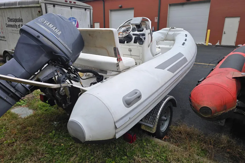 Slide: The Image of 2010 Nautica RIB 15 boat with Yamaha engine on trailer, parked outdoors. - 4