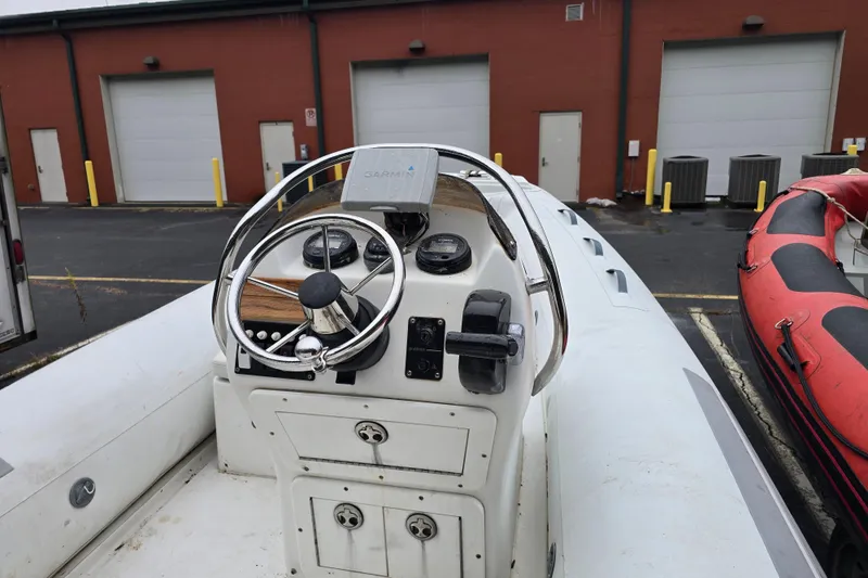 Slide: The Image of 2010 Nautica RIB 15 boat dashboard with steering wheel and controls. - 5