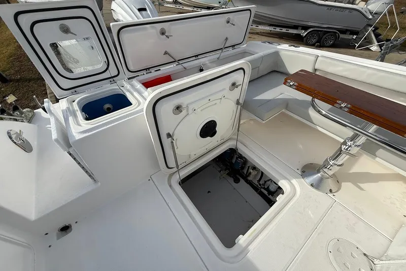 Slide: The Image of 2020 Everglades 340 Dual Console boat interior with open storage compartments and seating area. - 15