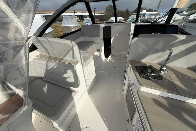 Slide: The Image of 2020 Everglades 340 Dual Console interior with seating and kitchenette. - 18