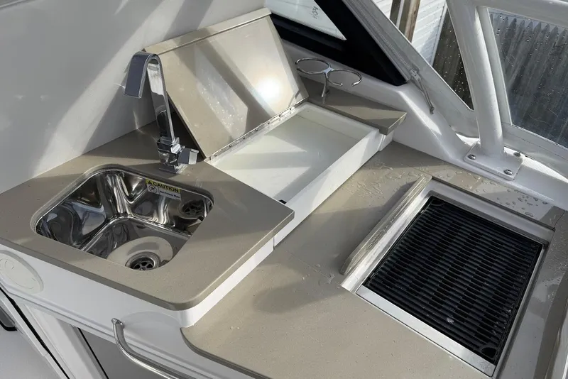 Slide: The Image of 2020 Everglades 340 Dual Console boat kitchen with sink and grill. - 20