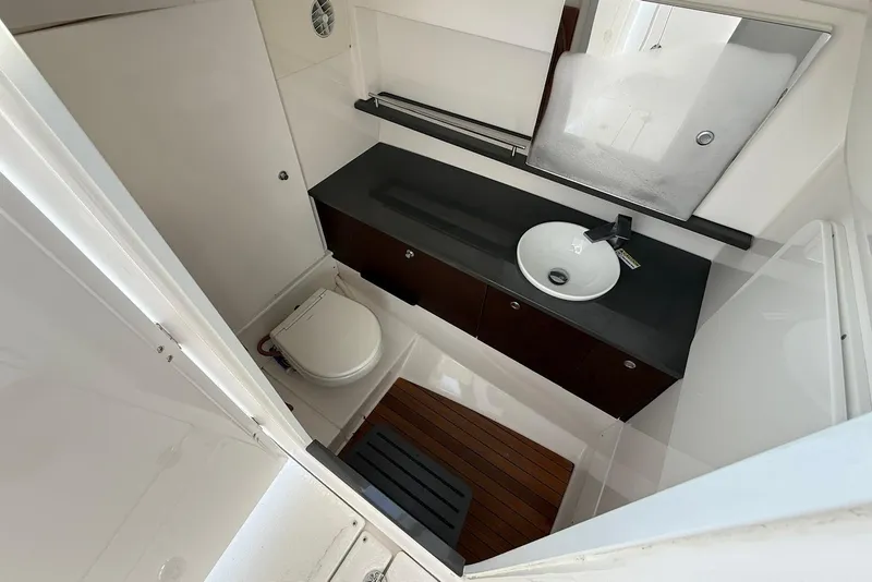 Slide: The Image of 2020 Everglades 340 Dual Console boat bathroom with sink, toilet, and wooden flooring. - 34