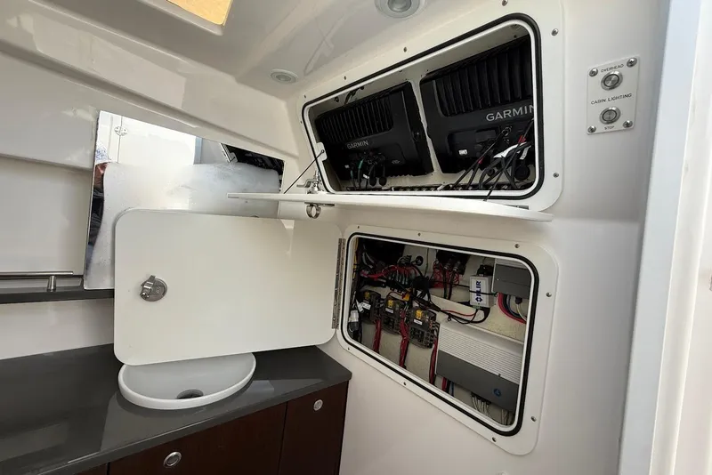 Slide: The Image of Interior view of 2020 Everglades 340 Dual Console boat's electrical panel and sink area. - 35