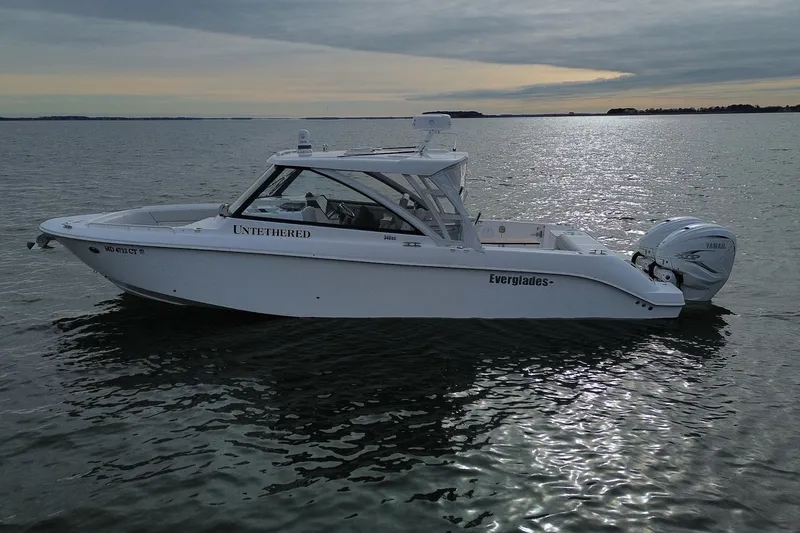 Slide: The Image of 2020 Everglades 340 Dual Console boat on calm water at sunset. - 5