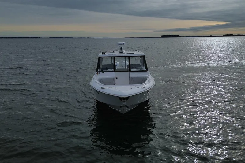 Slide: The Image of 2020 Everglades 340 Dual Console boat on calm water under cloudy sky. - 6