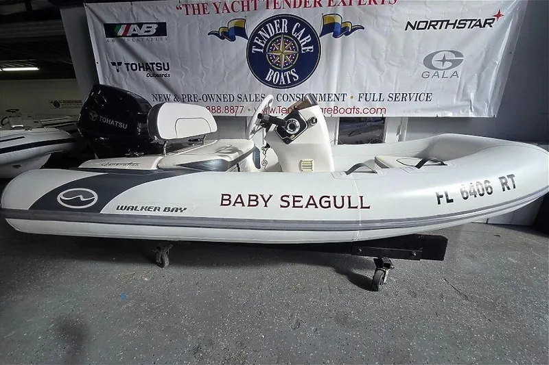 Slide: The Image of 2018 Walker Bay Supertender 365 inflatable boat, labeled "Baby Seagull," displayed indoors. - 10
