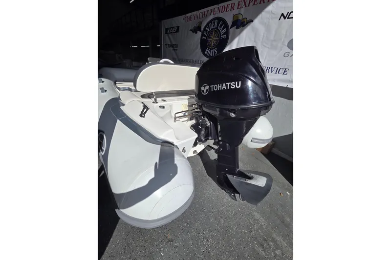 Slide: The Image of 2018 Walker Bay Supertender 365 with Tohatsu outboard motor, displayed indoors. - 8