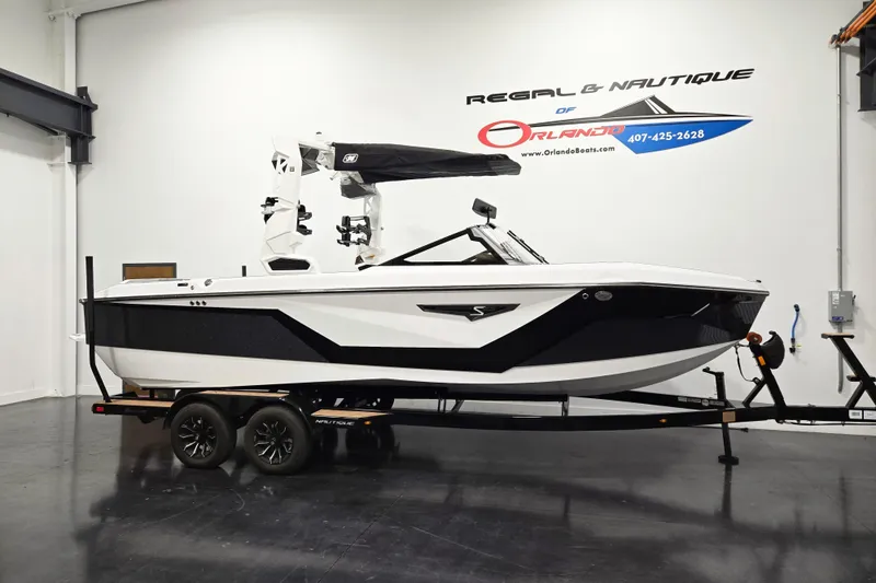 The Image of 2026 Nautique Super Air Nautique S23 boat on trailer in showroom. - 0