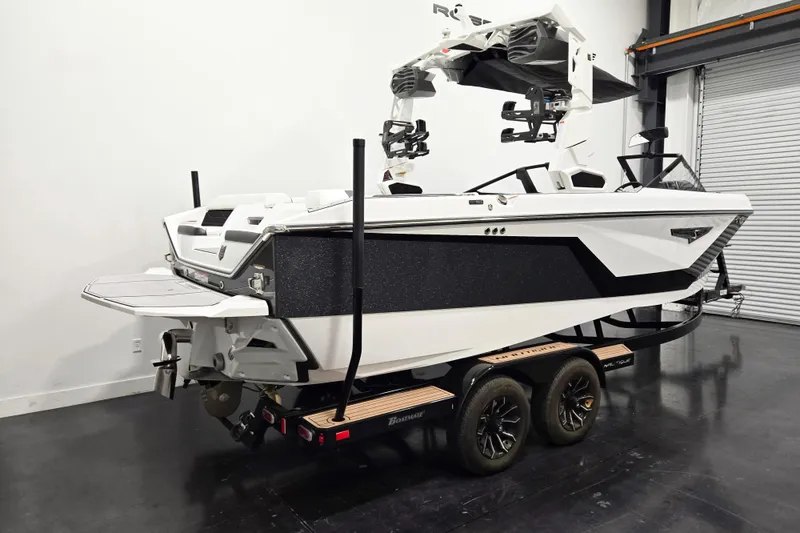 Slide: The Image of 2026 Nautique Super Air Nautique S23 boat on trailer in showroom. - 2