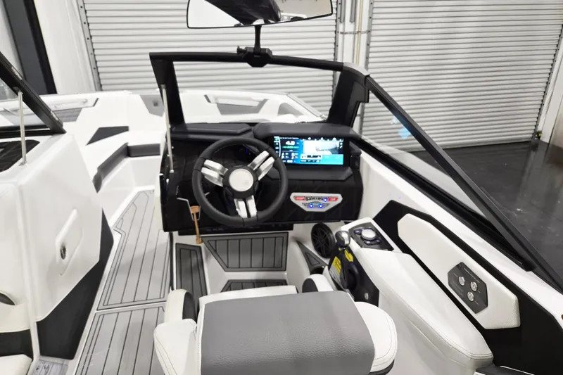 Slide: The Image of 2026 Nautique Super Air Nautique S23 boat interior with modern dashboard and steering wheel. - 4