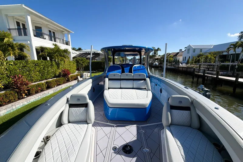 Slide: The Image of 2023 Mystic Powerboats M3800 luxury boat docked by waterfront homes. - 10