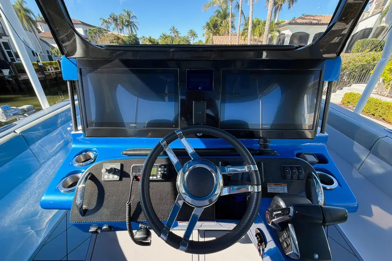 Slide: The Image of 2023 Mystic Powerboats M3800 helm with dual screens and sleek steering wheel. - 4