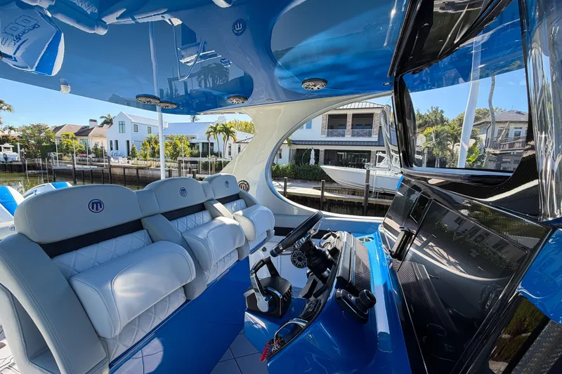 Slide: The Image of Interior of 2023 Mystic Powerboats M3800, featuring luxurious seating and modern dashboard. - 6