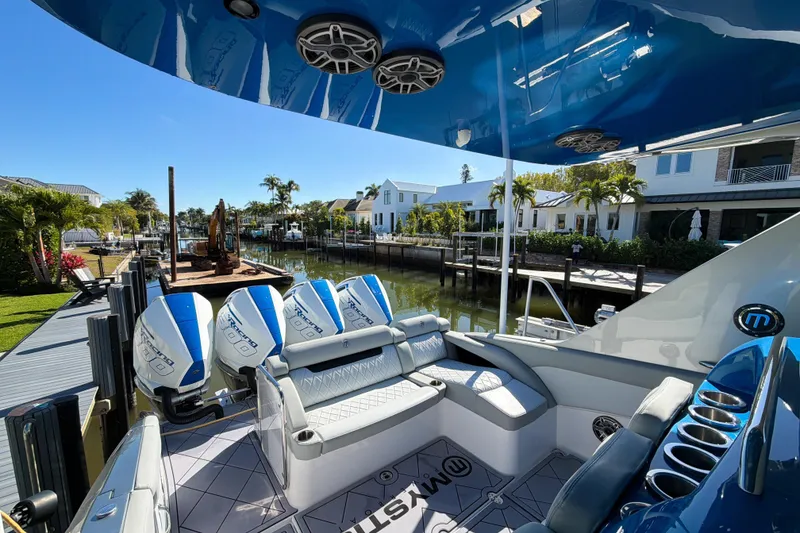 Slide: The Image of 2023 Mystic Powerboats M3800 docked, showcasing luxurious seating and powerful engines. - 7