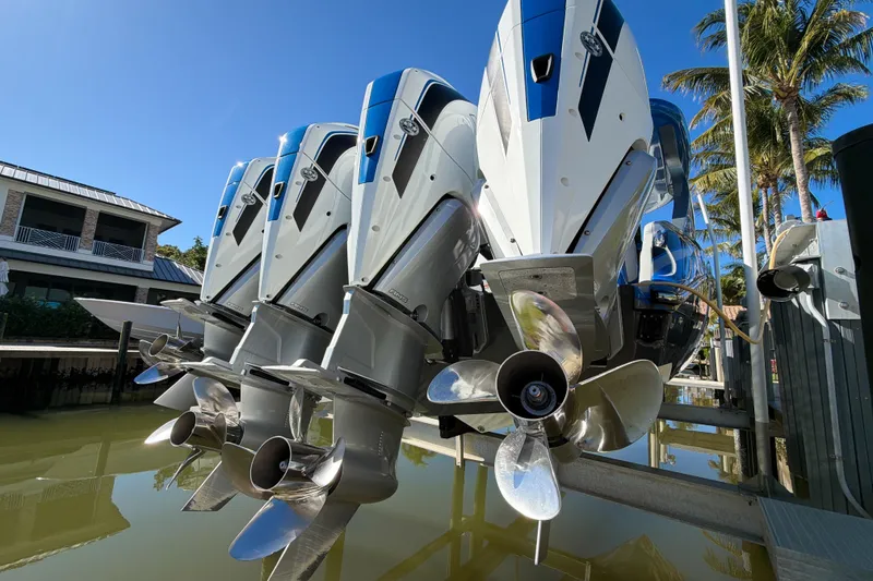 Slide: The Image of 2023 Mystic Powerboats M3800 with triple outboard engines docked near palm trees. - 9