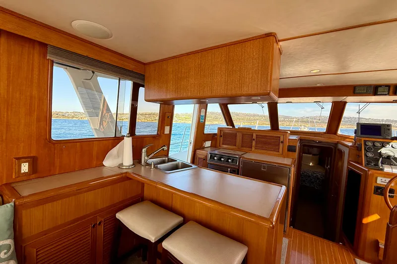 Slide: The Image of Interior of 1997 Offshore Yachts 48 Sedan, featuring a wooden kitchen and ocean view. - 38