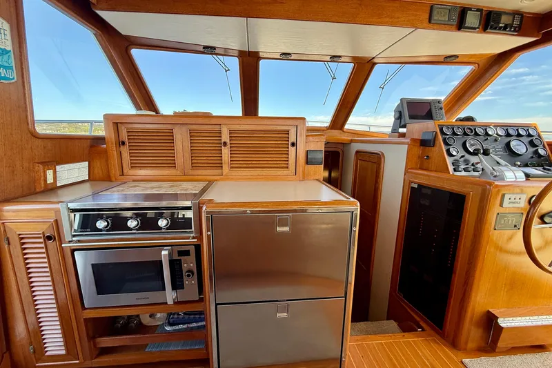 Slide: The Image of 1997 Offshore Yachts 48 Sedan interior with kitchen and navigation controls. - 42