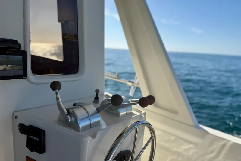 Slide: The Image of 1997 Offshore Yachts 48 Sedan helm with ocean view and control levers. - 55