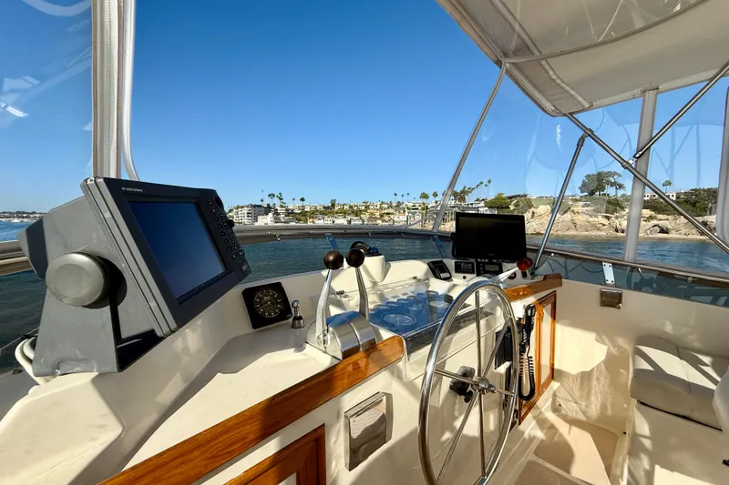 Slide: The Image of Cockpit view of 1997 Offshore Yachts 48 Sedan with navigation equipment and ocean scenery. - 75