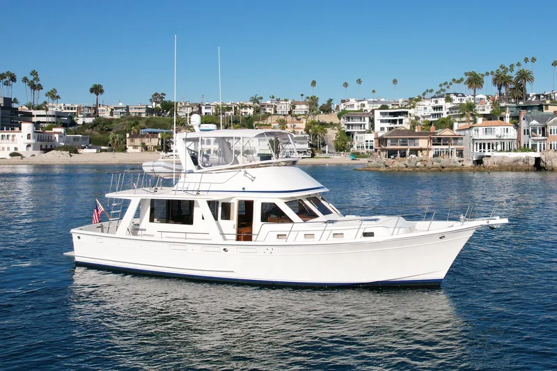 The Image of 1997 Offshore Yachts 48 Sedan cruising near coastal homes. - 0