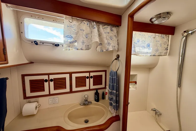 Slide: The Image of Bathroom interior of 1997 Offshore Yachts 48 Sedan with sink, shower, and nautical decor. - 18
