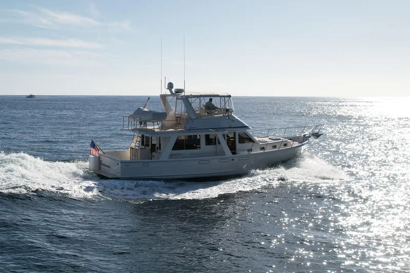 Slide: The Image of 1997 Offshore Yachts 48 Sedan cruising on open water under clear skies. - 4