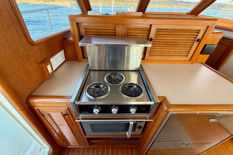 Slide: The Image of 1997 Offshore Yachts 48 Sedan kitchen with stove and wooden cabinetry. - 43