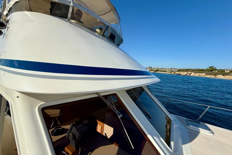 Slide: The Image of 1997 Offshore Yachts 48 Sedan cruising on clear blue waters under a sunny sky. - 54