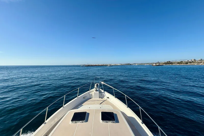 Slide: The Image of Bow view of 1997 Offshore Yachts 48 Sedan cruising on open sea. - 61