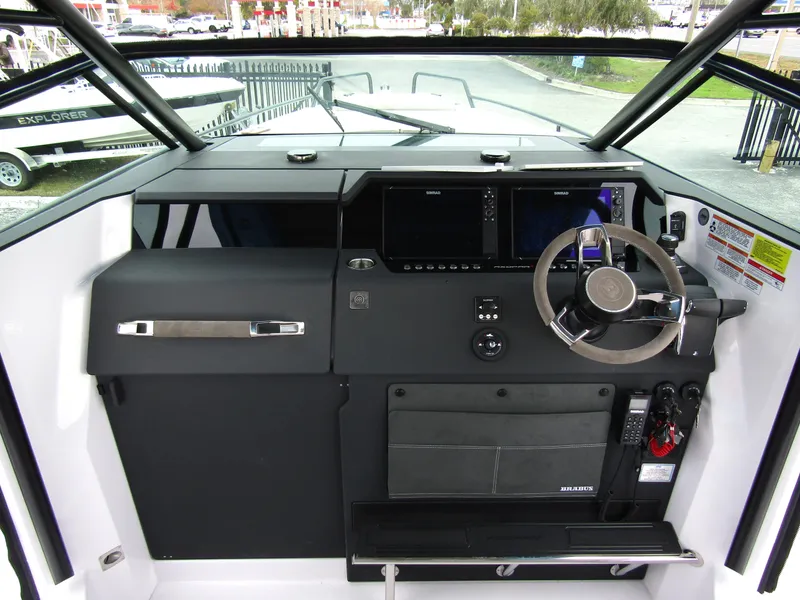 Slide: The Image of 2024 Axopar 37 Sun Top helm with modern navigation controls and steering wheel. - 24