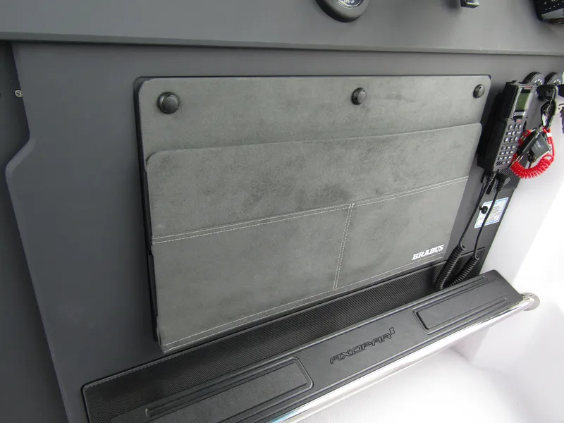 Slide: The Image of 2024 Axopar 37 Sun Top dashboard with storage compartment and communication equipment. - 31