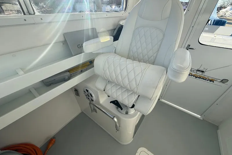 Slide: The Image of Captain's chair in 2023 Steiger Craft 31 Chesapeake boat interior, featuring white quilted upholstery. - 26