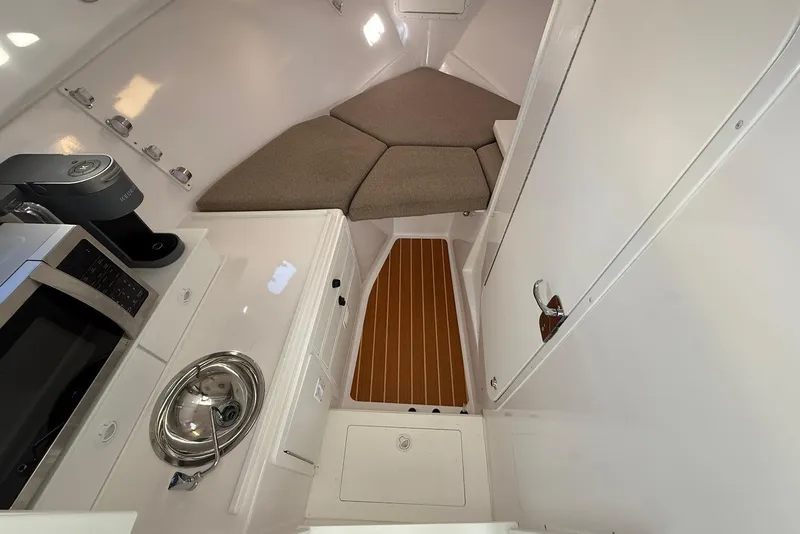 Slide: The Image of 2023 Steiger Craft 31 Chesapeake cabin interior with kitchenette, sink, and cozy seating area. - 32