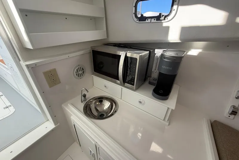 Slide: The Image of Compact kitchenette in 2023 Steiger Craft 31 Chesapeake boat with microwave, sink, and coffee maker. - 33