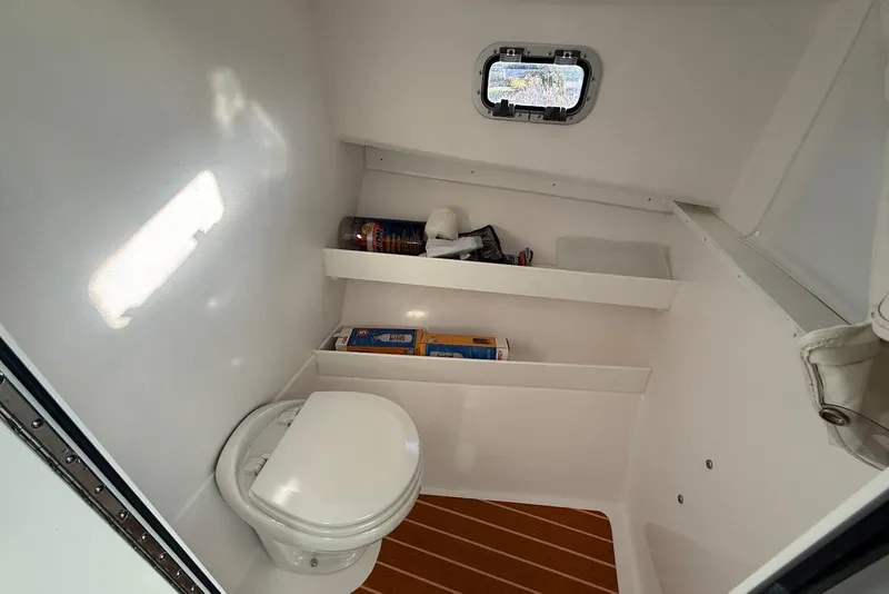 Slide: The Image of 2023 Steiger Craft 31 Chesapeake boat interior bathroom with toilet and shelves. - 36